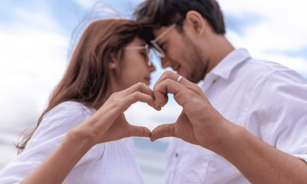 a man and a woman holding up a heart