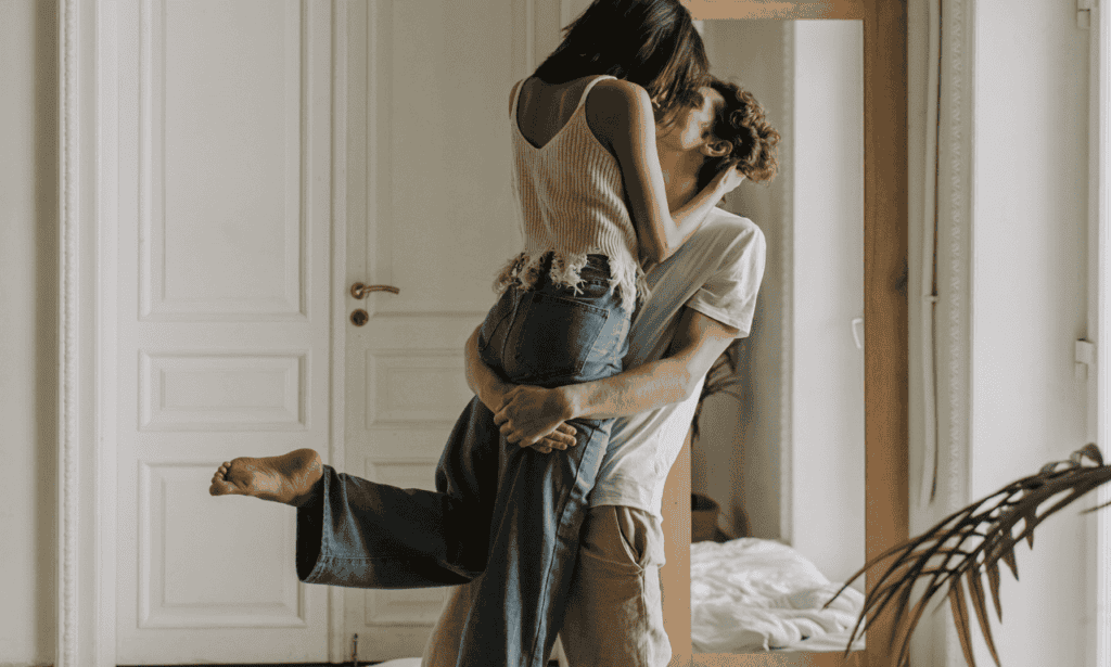 Couple kissing each other, while the guy is holding the girl up in the air!