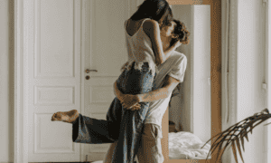 Couple kissing each other, while the guy is holding the girl up in the air!