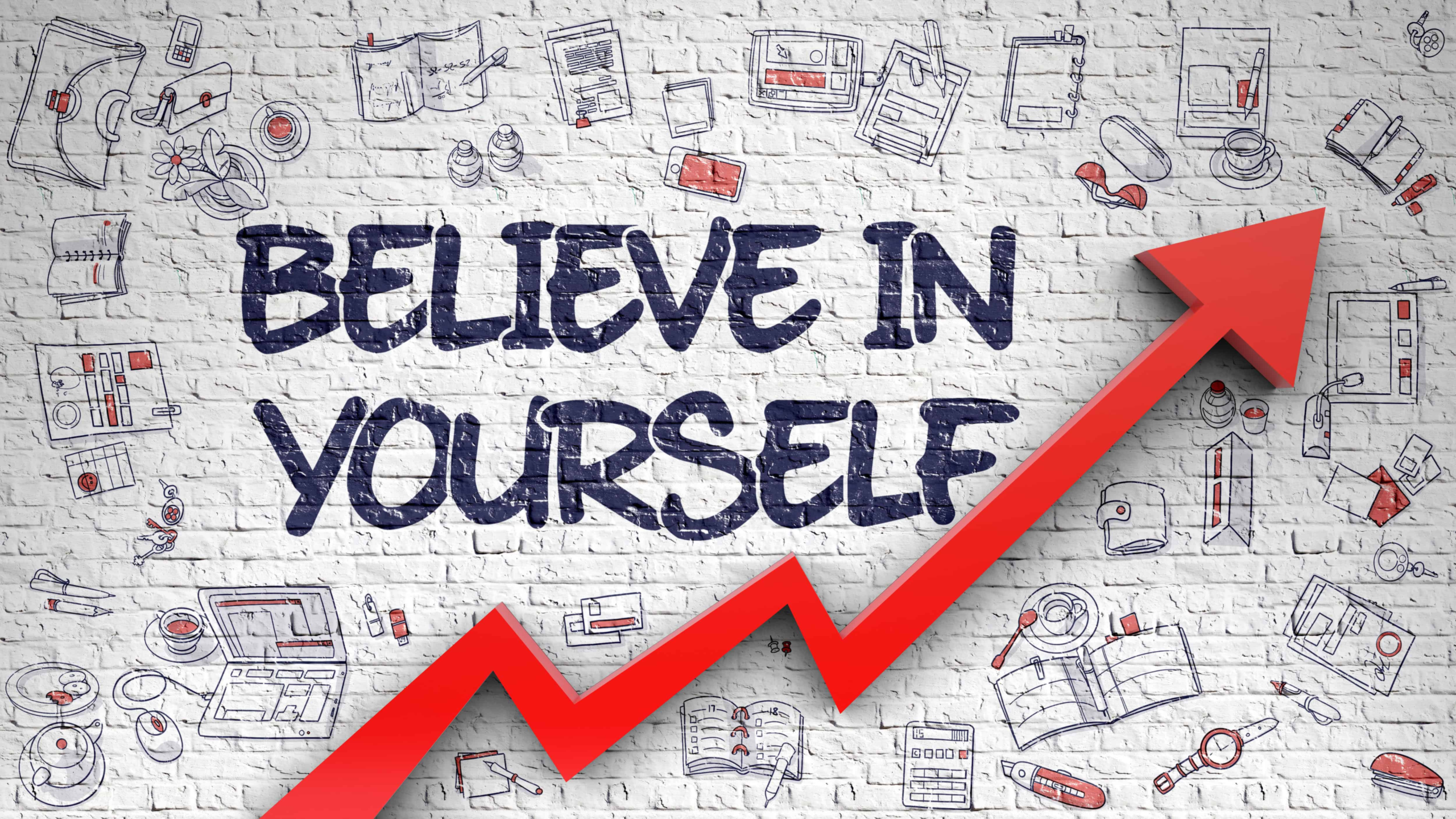 A brick wall with lots of cool drawings all over it with the words believe in yourself in a bold font!