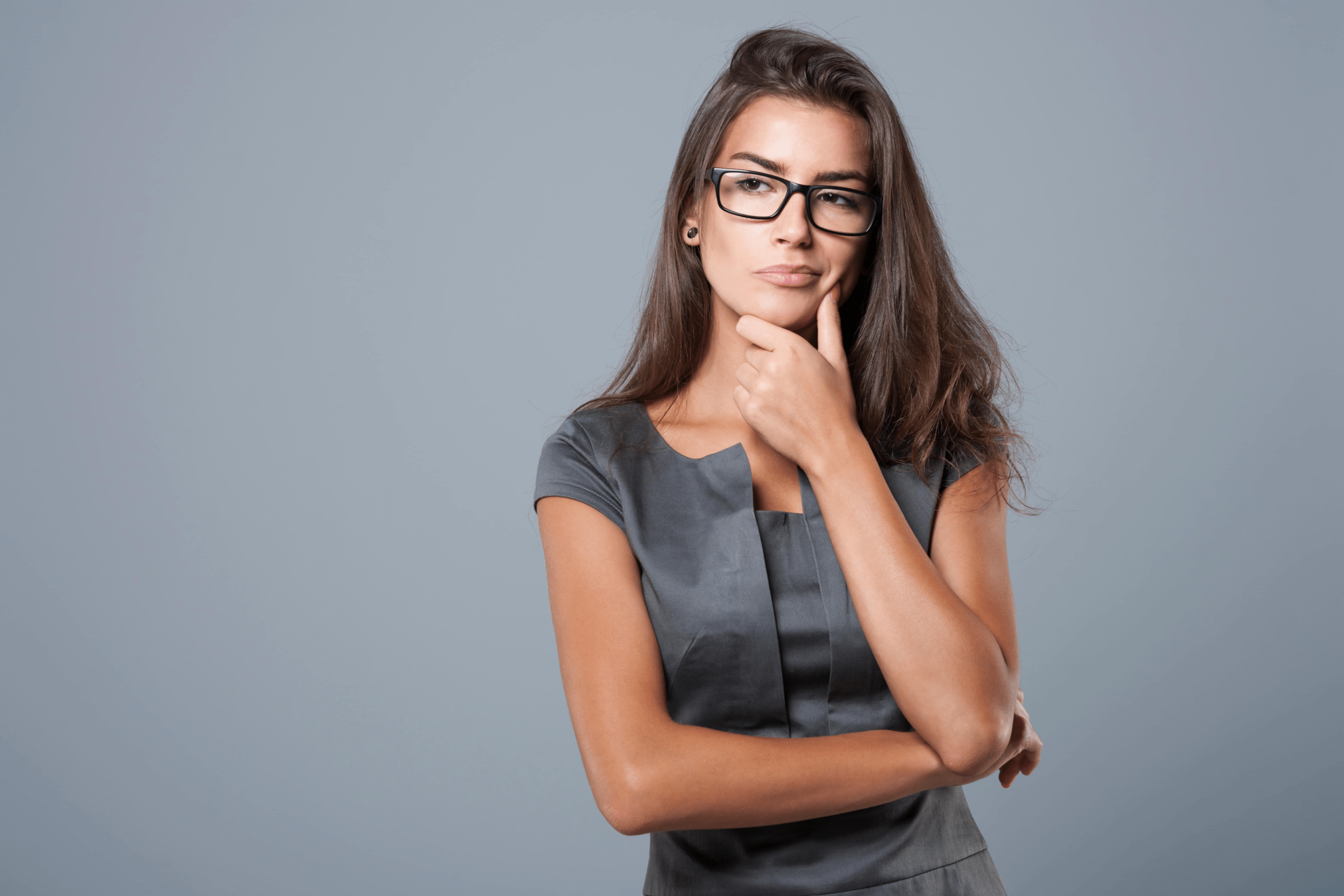 A beautiful woman with glasses on and a thinking face.