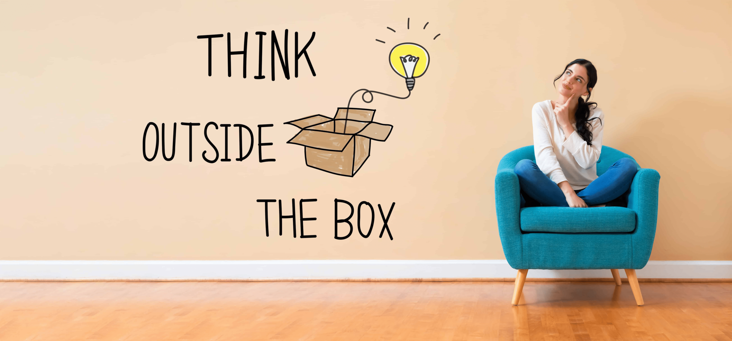 A woman sitting in a blue chair looking up., representing thinking outside the box!