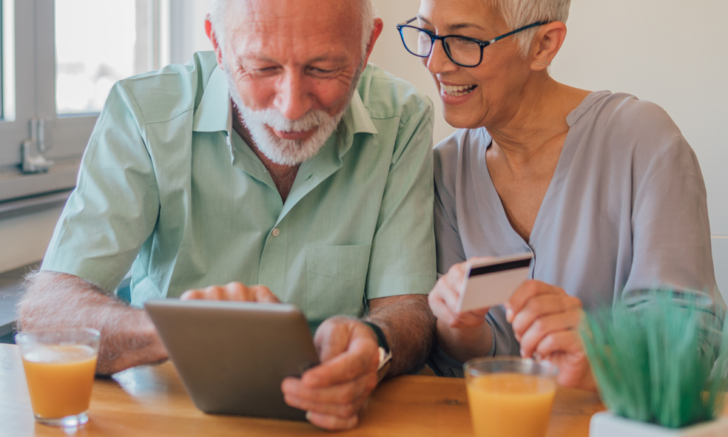 a couple sitting together at the kitchen table talking and booking a trip together.