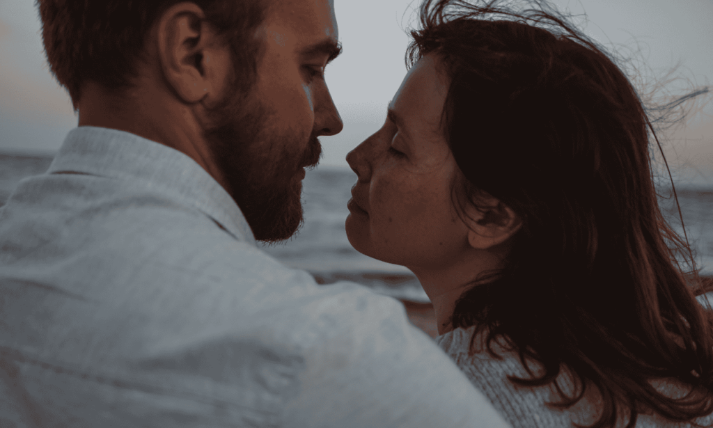 white couple holding each other tightly about to kiss