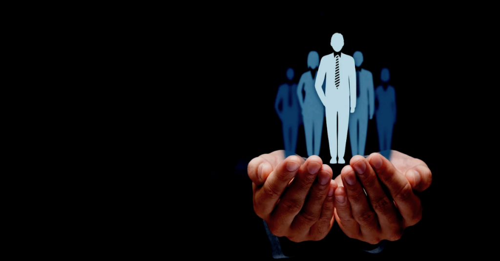 A person holding their hands out. Inside of their hands isa group of people.