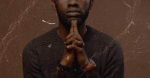 a black man with praying hands