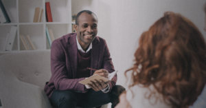 A couple talking with a black therapist both of them trying to heal their trauma and heal their marriage.