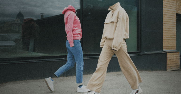 Two people walking past each other in the street with no heads, representing the disconnect.